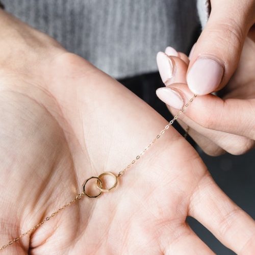 Hand håller i ett armband, ditt första äkta smycke