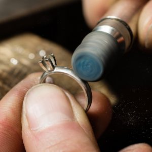 guldsmed slipar ring under smyckesutbildning